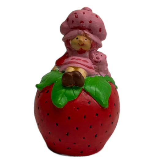 Girl Sitting on Strawberry Statue